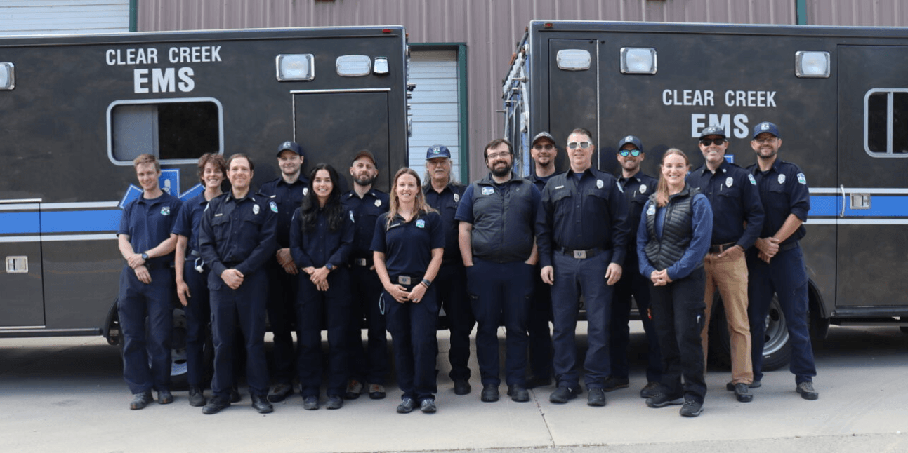 A photo with members of Clear Creek EMS lined up in front of two ambulances.